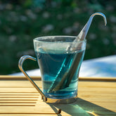 Sleek stainless steel tea steeper displayed with aromatic loose leaf tea